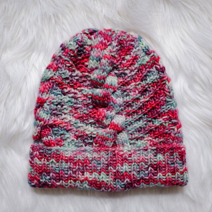 Ash Cave Beanie in Benjamin (red and gray) on a white fur background