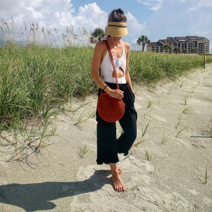 Woman wearing a Beach Day Bag Crochet shoulder bag while standing on a beach