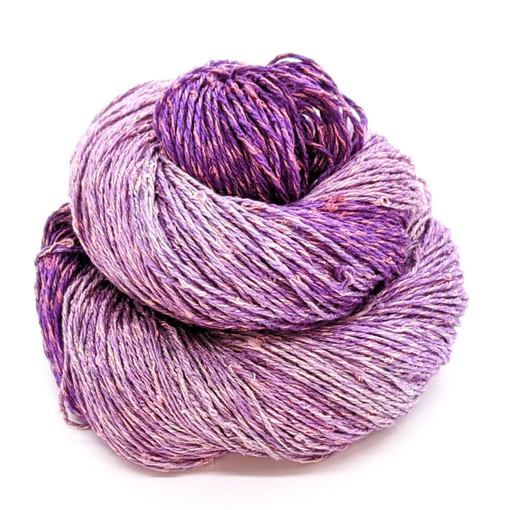 80 20 blend yarn in the colorway Grape, variegated dark and light purple sitting in front of a white background.