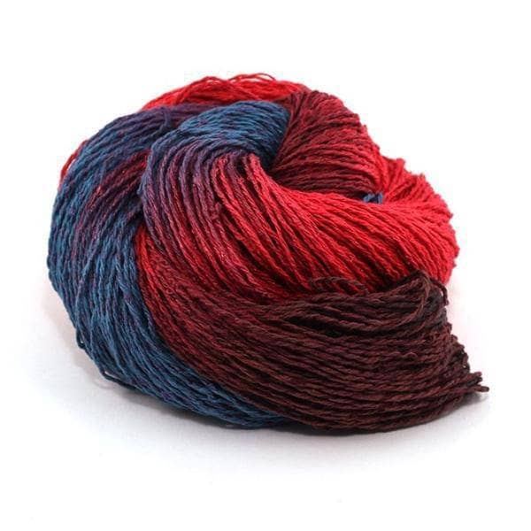 Silk blend sport weight yarn donut ball in Wine Date (red and blue) on a white background