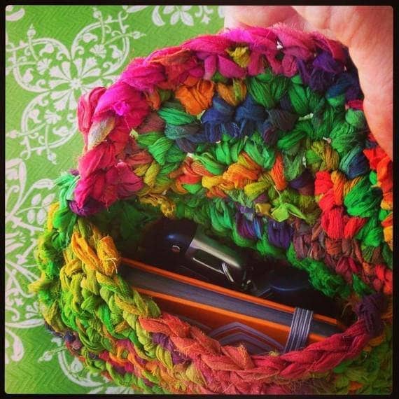 Small knitted clutch in multicolor on a green backdrop