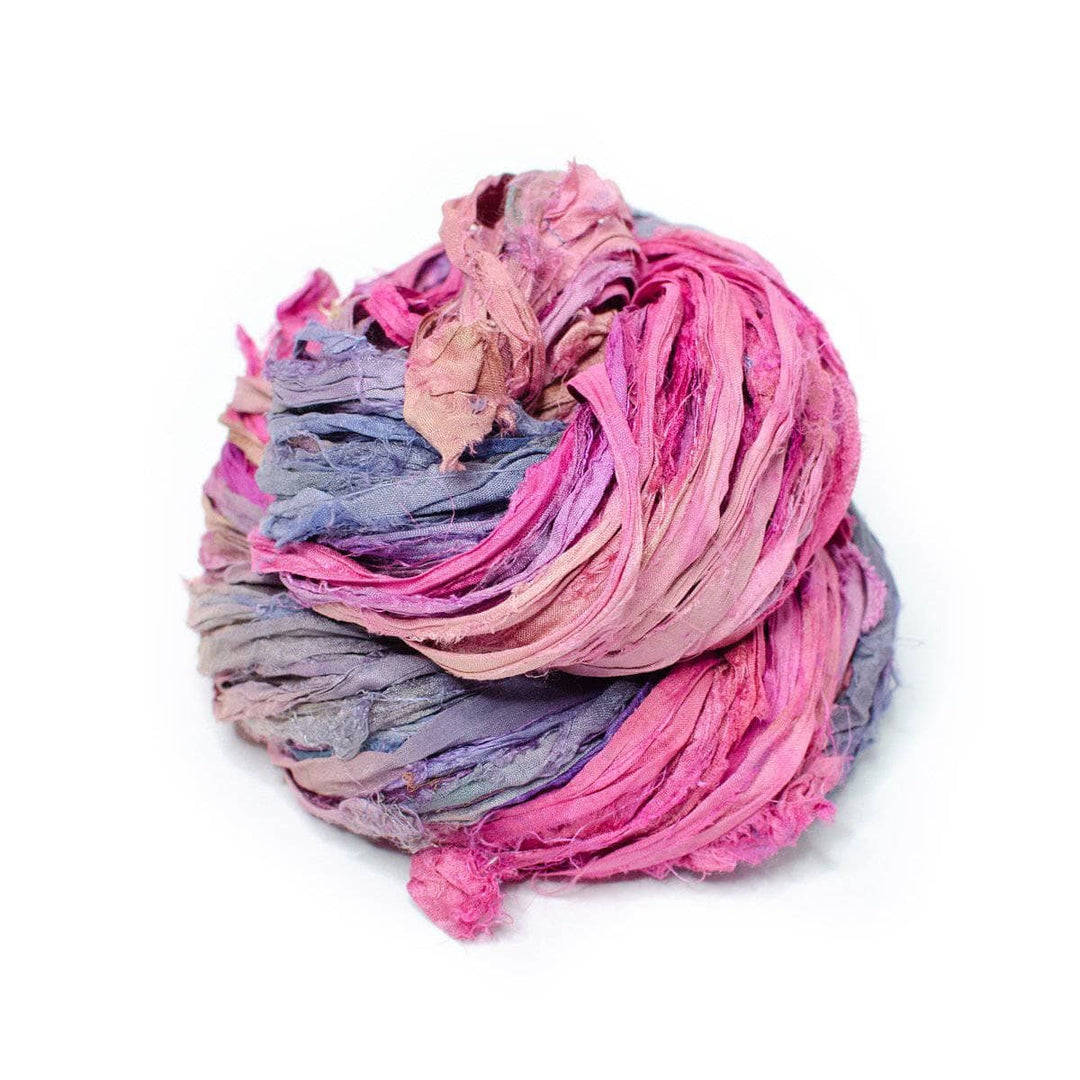 a skein of pink and purple and yellow ribbon yarn on a white background