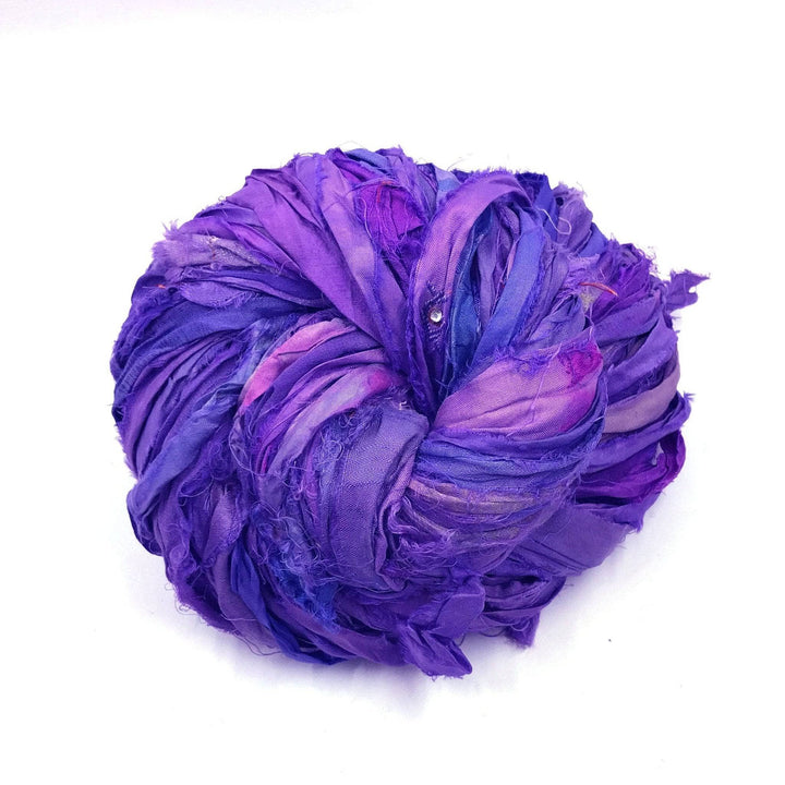 a skein of purple ribbon yarn on a white background