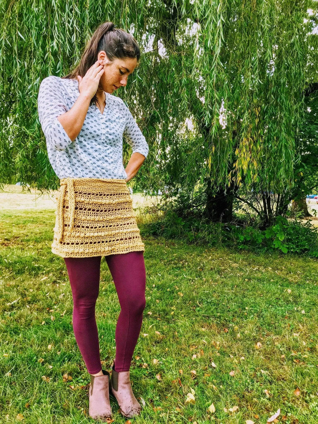 A woman wearing a beige crocheted skirt outside