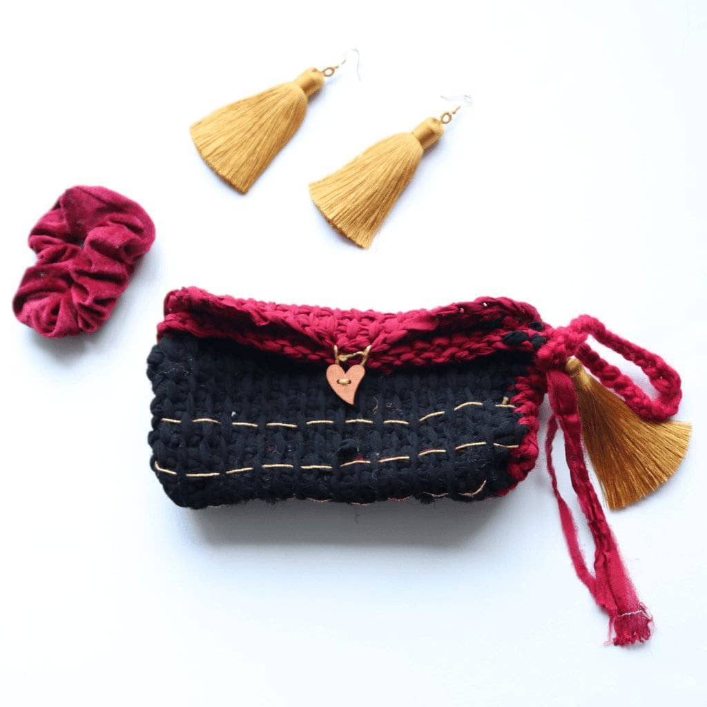 black, and pink clutch on a white background with gold thread earrings and a scrunchies 