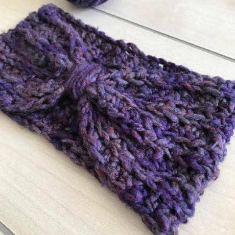 purple crocheted Bow Ear Warmer in front of a white background
