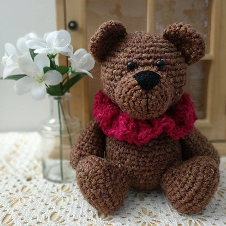 Brown Bear Amigurumi Crochet stuffed animal sitting on a lace tablecloth