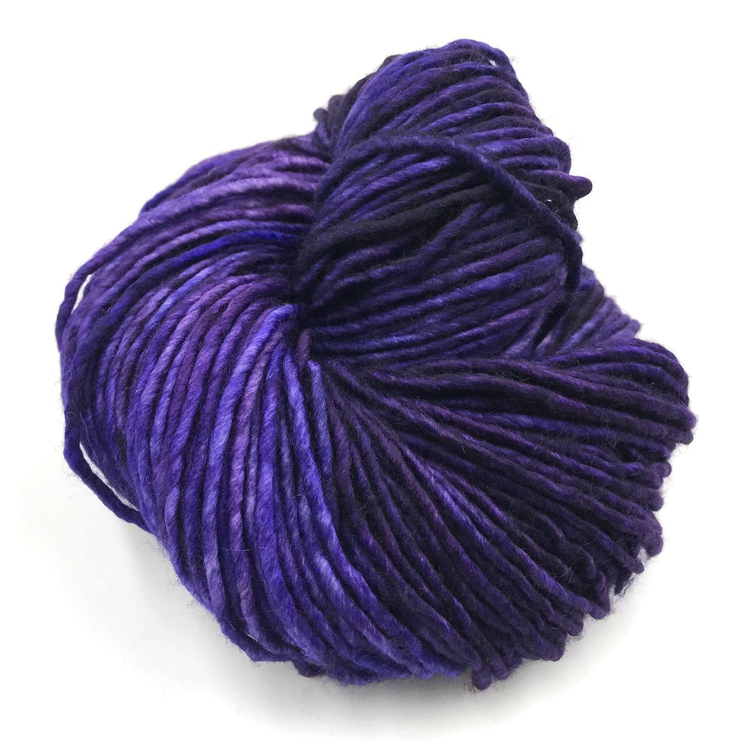 A multi-shaded purple skein of yarn on a white background