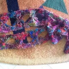 Multicolored crochet Butterfly Scarf laying on a tan doormat