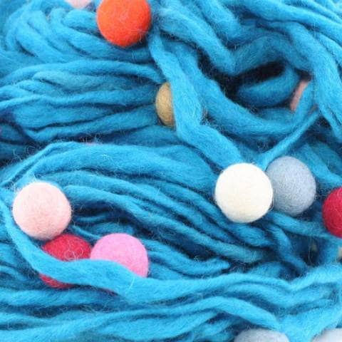 Close up of thick and thin felt ball yarn in blue