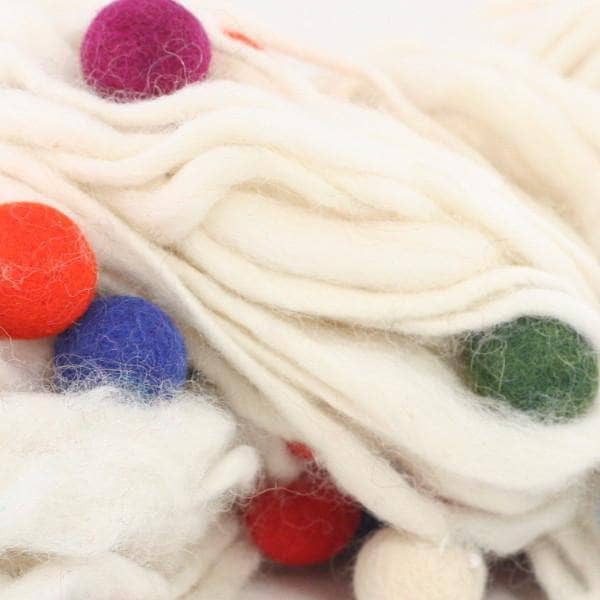 Close up of thick and thin felt ball yarn in White