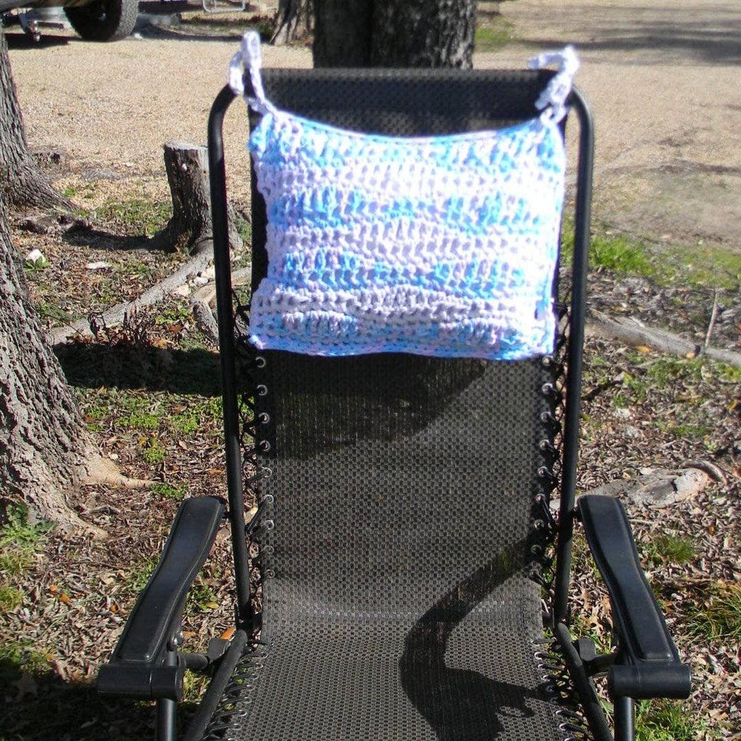 Blue and lavender crocheted Cast Away pillow tied to a black outdoor chair