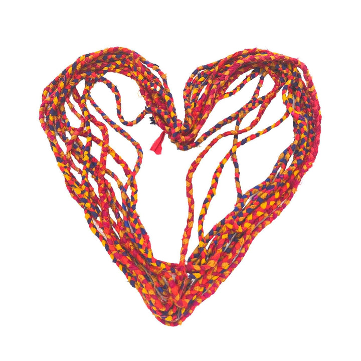 choti sari silk ribbon yarn retro rainbow untwisted and shaped into a heart in front of a white background.