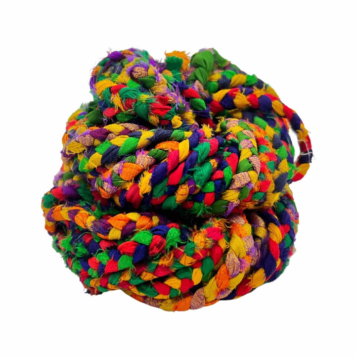 retro rainbow braided sari silk ribbon yarn in birds nest in front of a white background
