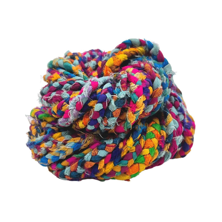 single skein of multicolor parrot feathers braided recycled ribbon yarn in front of a white background.