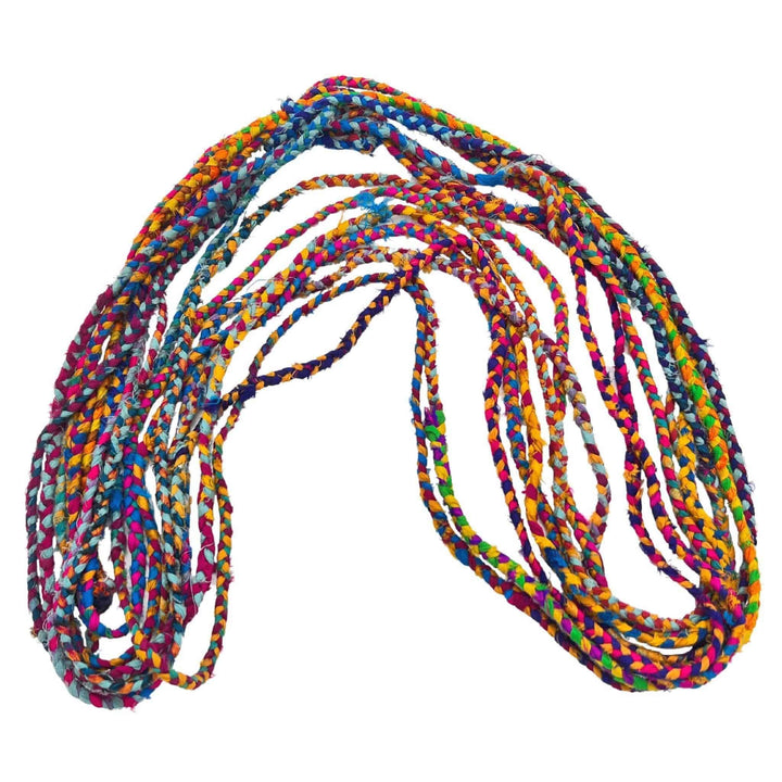 untwisted skein of braided sustainable sari silk ribbon yarn in rainbow shape in front of a white background to show detail.