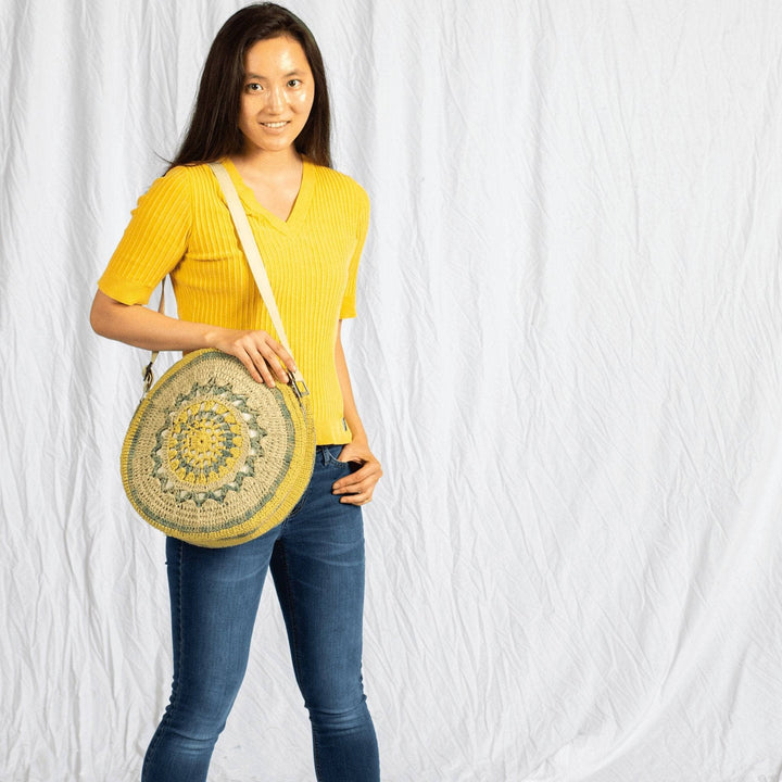 Girl wearing Circle Banjo Bag Crochet Kit with yellow shirt on a white background