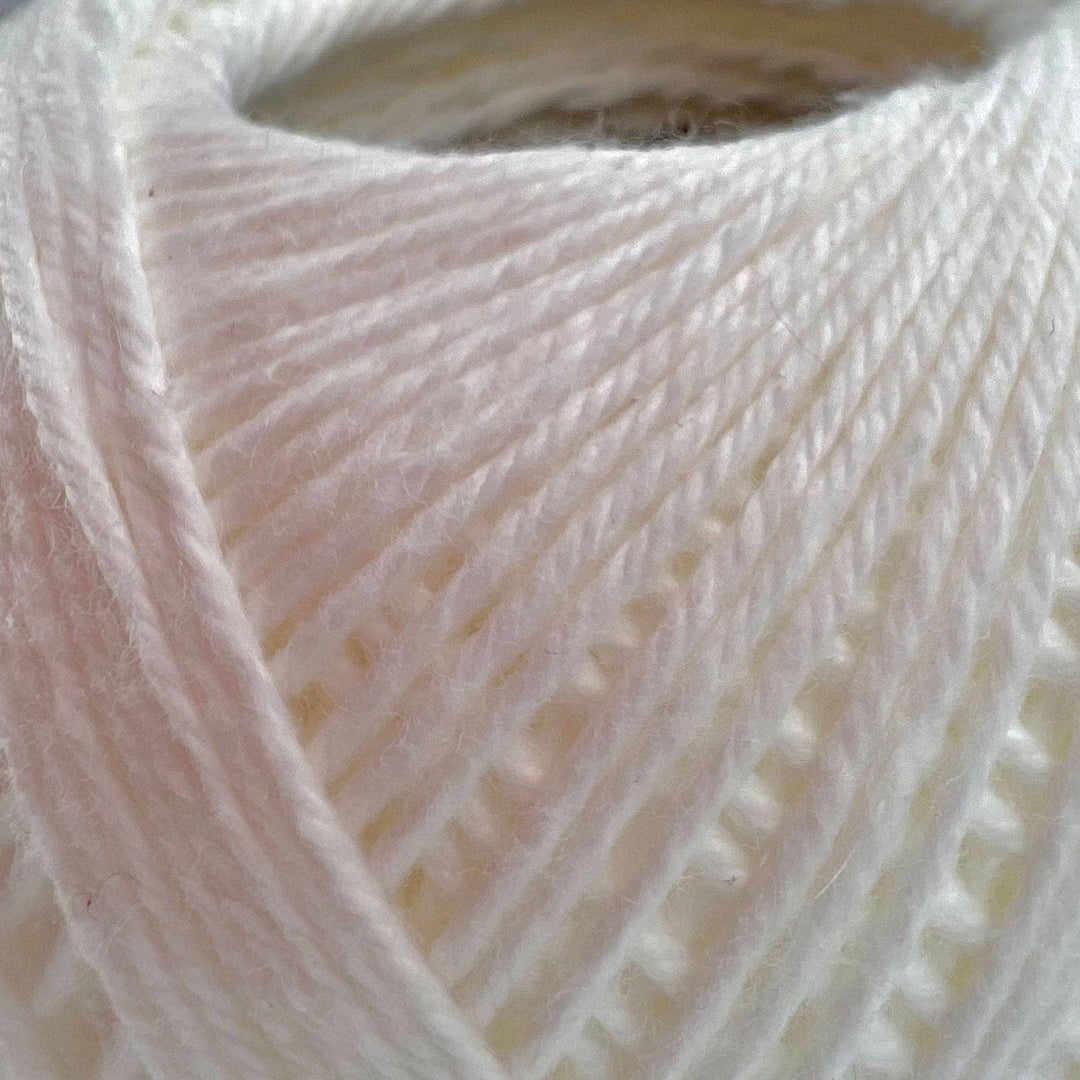 close up image of white cotton yarn to show detail.
