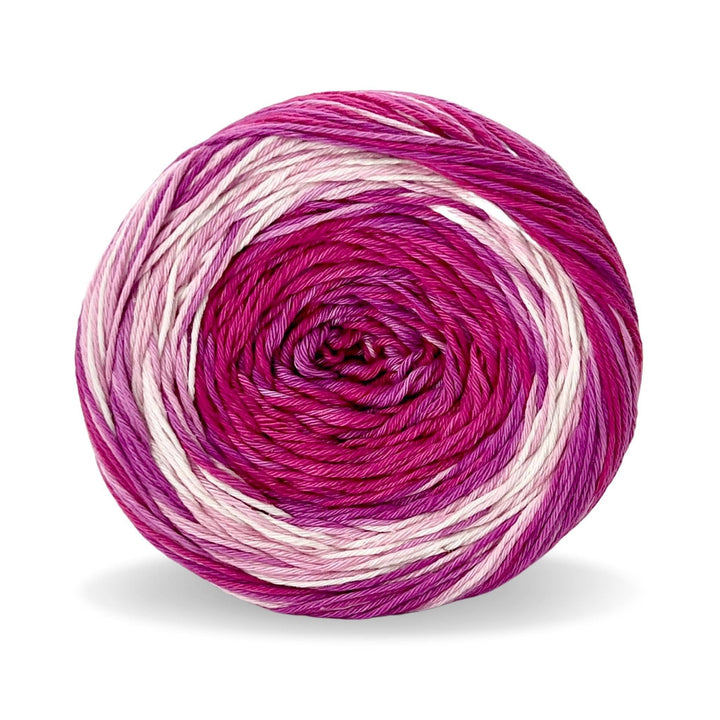 Cake of circulo whoopee lychee cotton yarn in front of a white background (magenta, fuchsia, and blush tonal yarn).