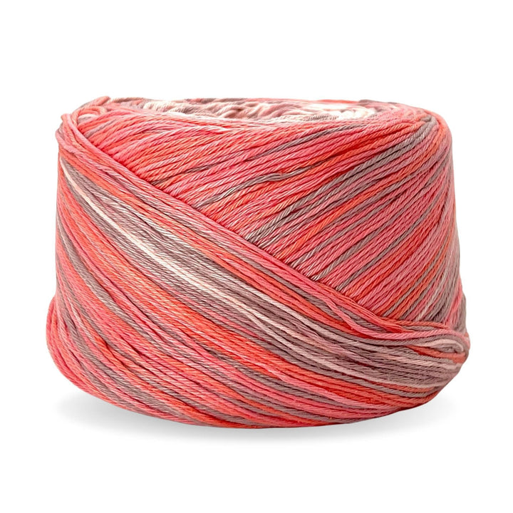 Cake of circulo whoopee stargazer lily cotton yarn in front of a white background (peach, salmon, and beige tonal yarn).