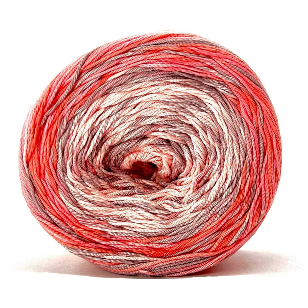 Cake of circulo whoopee stargazer lily cotton yarn in front of a white background (peach, salmon, and beige tonal yarn).