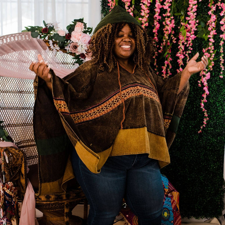 Model wearing green claire hooded poncho in front of a colorful background.