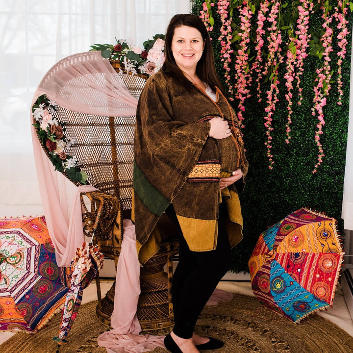 Model wearing green claire hooded poncho in front of a colorful background.