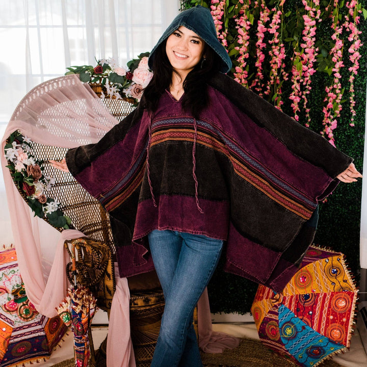 Model wearing purple claire hooded poncho in front of a colorful background.