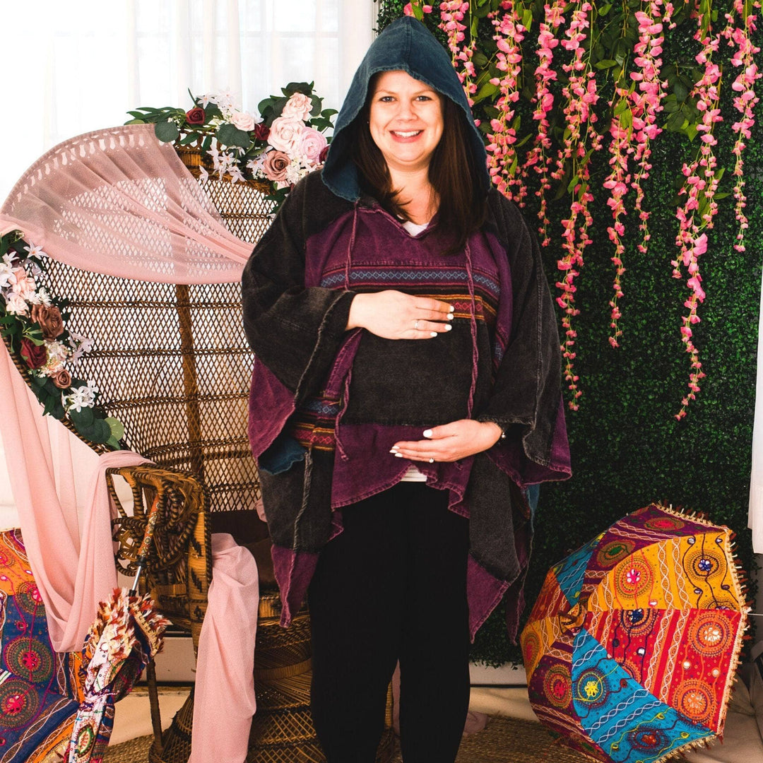 Model wearing purple claire hooded poncho in front of a colorful background.