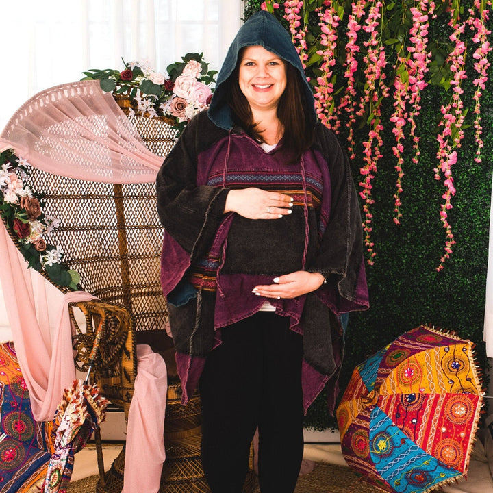 Model wearing purple claire hooded poncho in front of a colorful background.