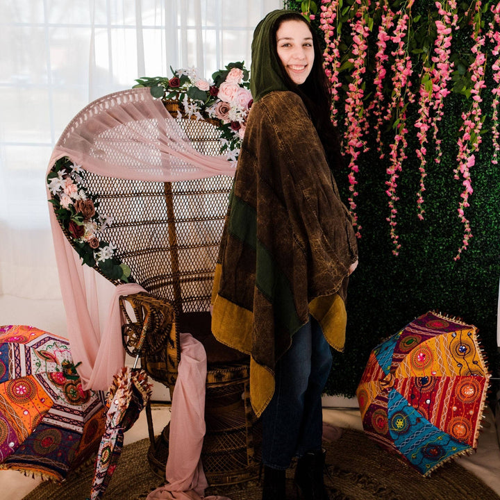 Model wearing green claire hooded poncho in front of a colorful background.
