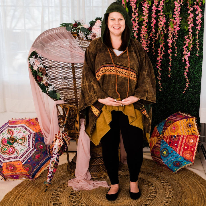 Model wearing green claire hooded poncho in front of a colorful background.