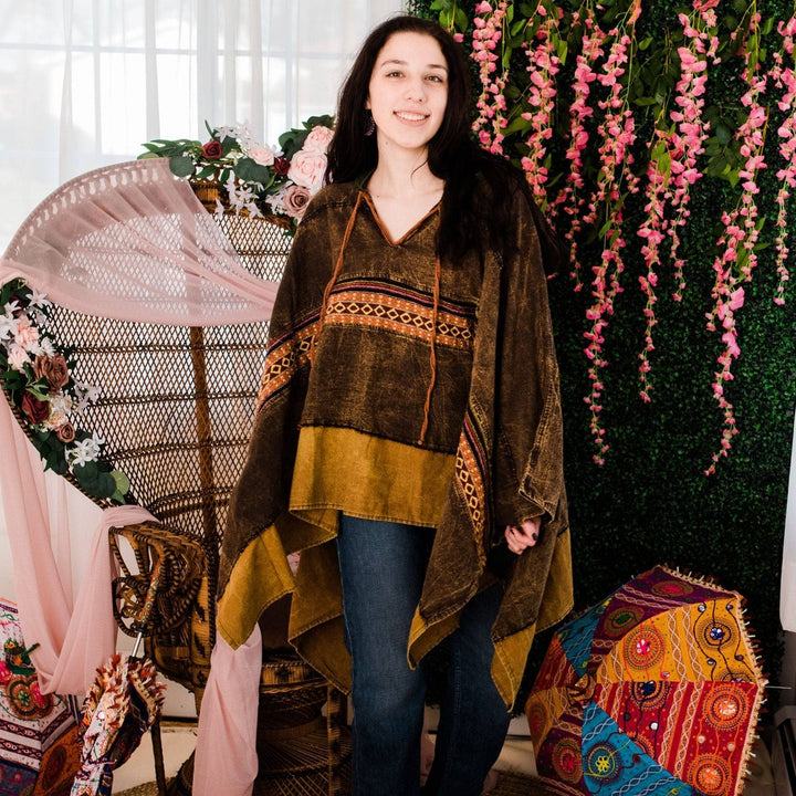 Model wearing green claire hooded poncho in front of a colorful background.