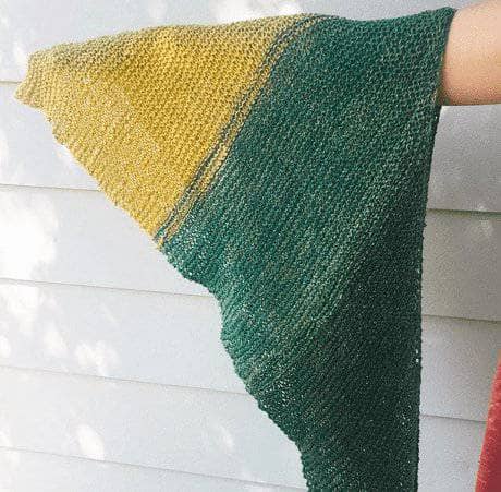 Woman's arm holding out a triangular green and yellow striped shawl