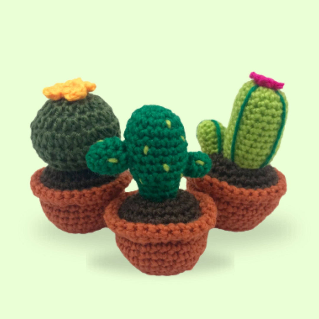 3 knit cacti amigurumis in knit terra cotta pots on a white background