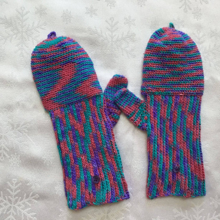 Blue, pink and purple mittens on a white background