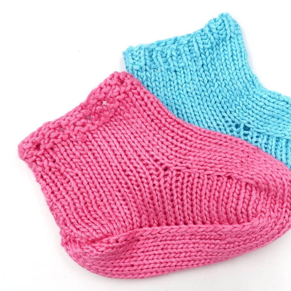 Pink and blue baby booties on a white background 