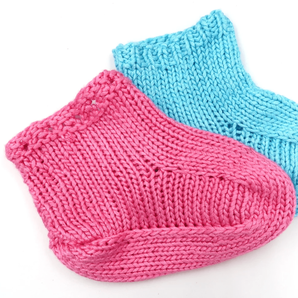 Pink and blue baby booties on a white background 