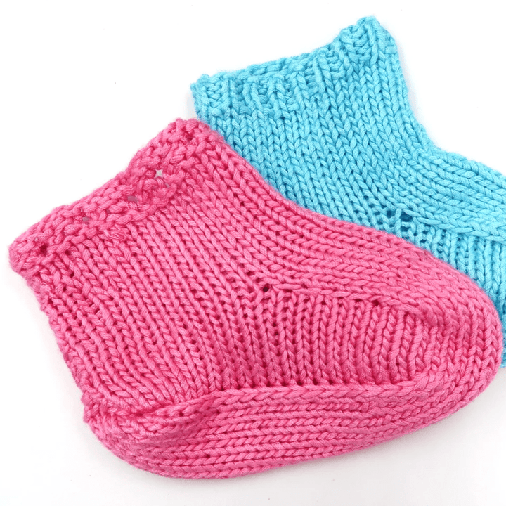 Pink and blue baby booties on a white background 