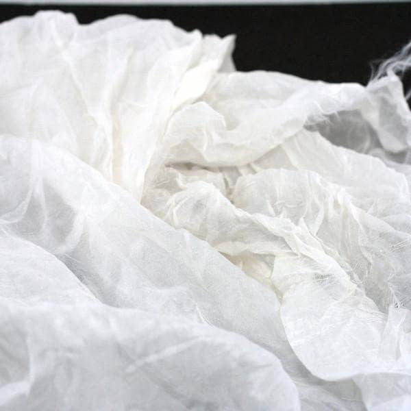 White crinkle chiffon fabric folded on a black background