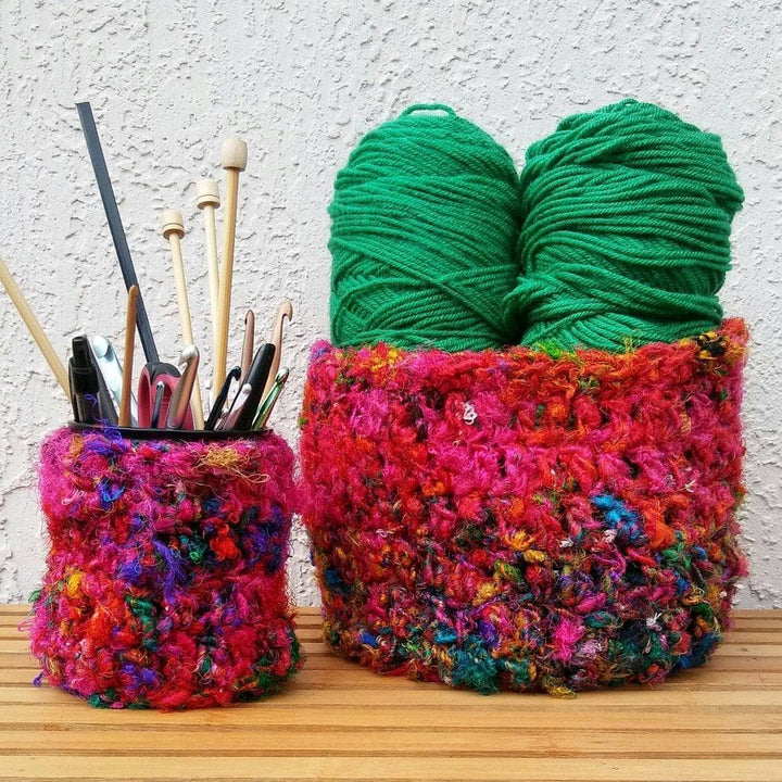 Yarn catchall baskets with crochet hooks and yarn inside of the baskets