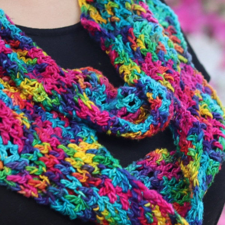Close up view of Woman wearing black tee shirt and multicolored crochet scarf