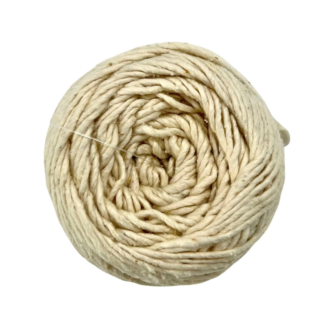 Cake of silk roving worsted weight yarn in the colorway dandelion poof (undyed) in front of a white background