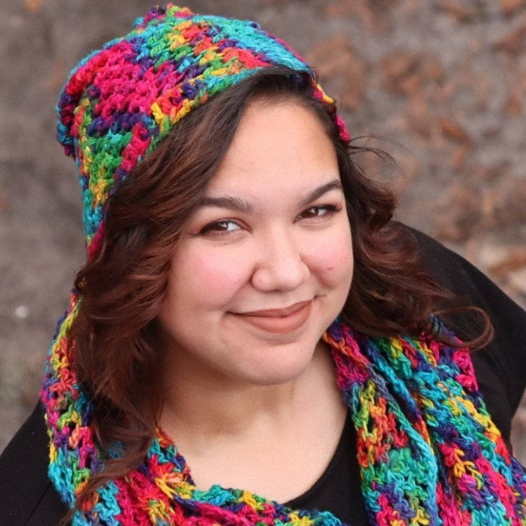 Close up of woman wearing a multicolored scarf and beanie set and a black t shirt