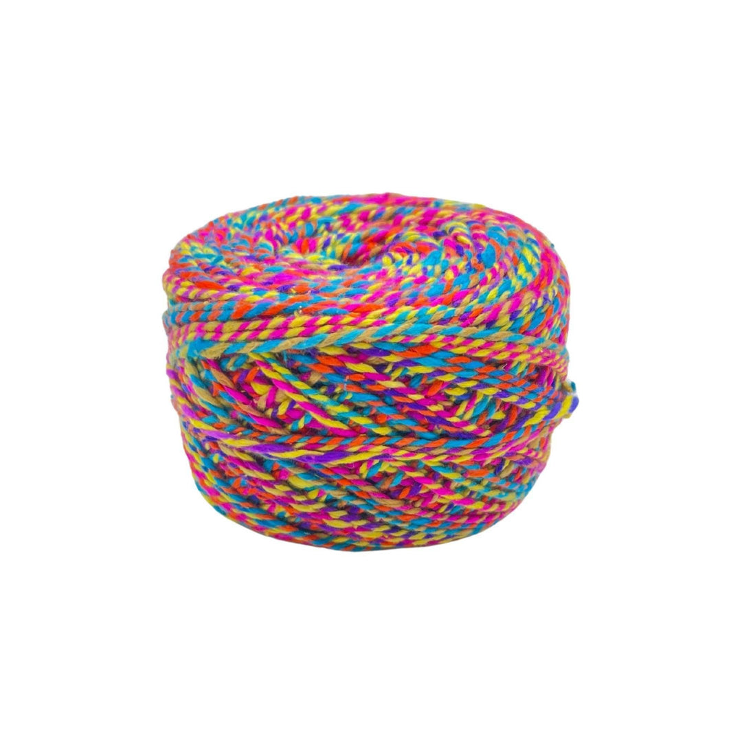 cake of sport weight silk in color way Dragon's Tail . Red, pink, blue, orange, and yellow marled yarn in front of a white background.