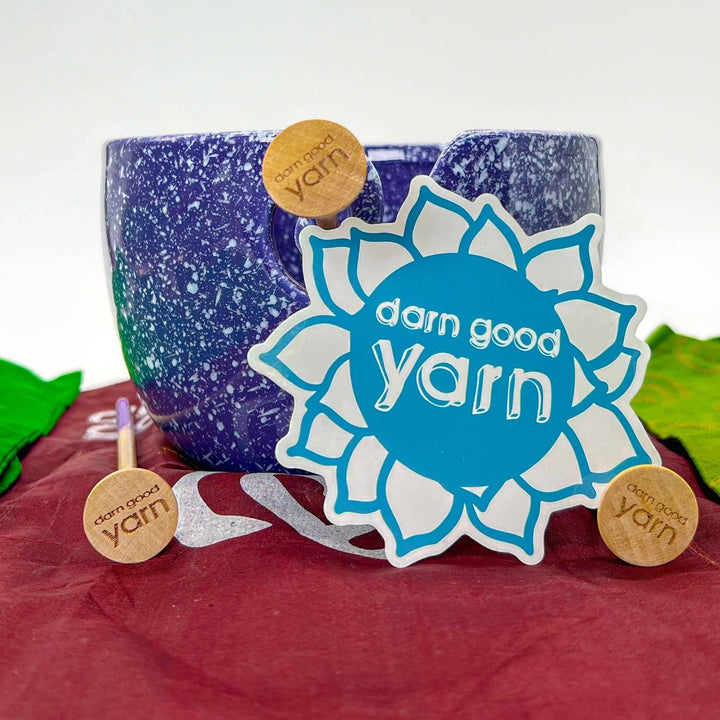 Closeup of ceramic yarn bowl with several items from the bundle included. 