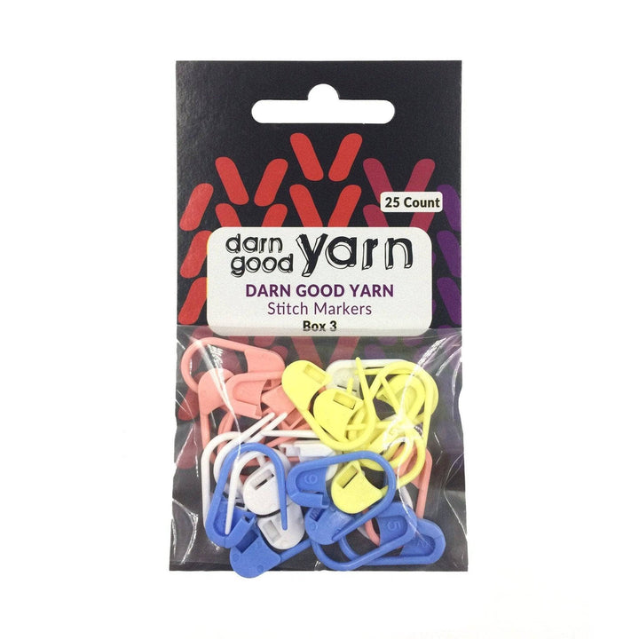 Small black and red envelope with clear plastic bag attached holding pastel plastic knit stitch markers and a label that reads 'Darn Good Yarn Stitch Markers'