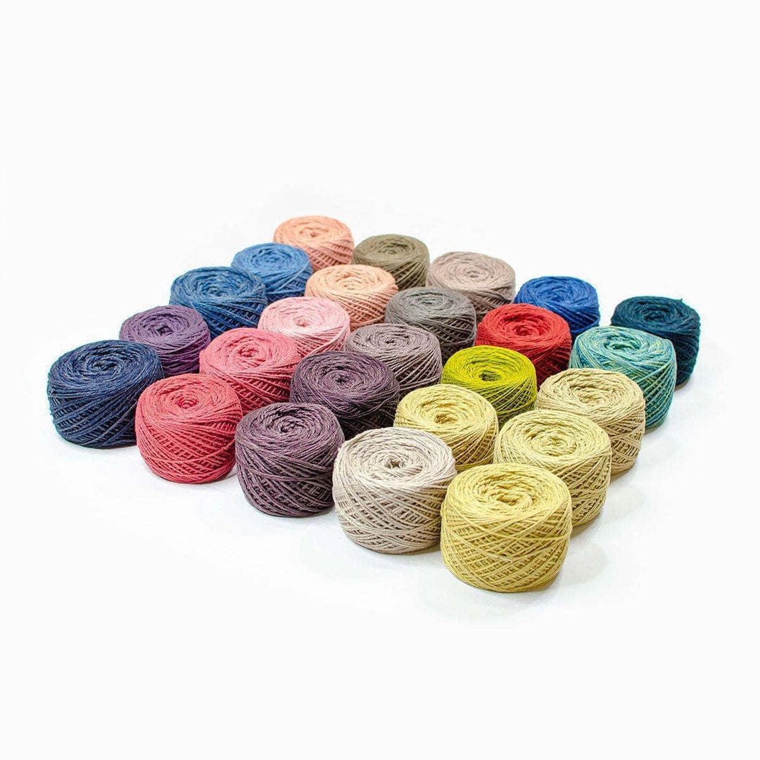 multiple yarn cakes in different colors over a white background