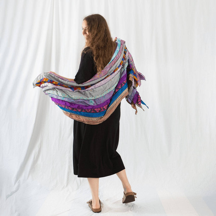 Founder Nicole wearing earth festival scarf in multicolor behind her in front of a white background.