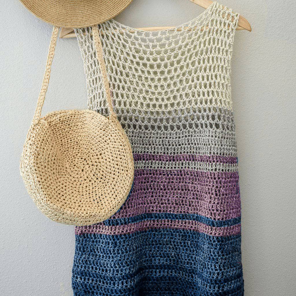 Easy Breezy Top Crochet kit shown in winter frost colorway with straw hat and bag hanging in front of a white background.